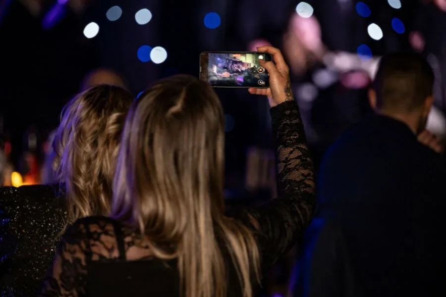 A guest holds up a phone to film the stage at the Ashford Hero Awards